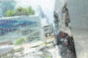 morgenstadt, blick durch das fenster an einem regnerischen tag. Wassertropfen auf dem Glas an einem regnerischen Tag. Regentropfen während des Regens an regnerischen Tagen außerhalb des Fensterglases mit verschwommenem Hintergrund. foto