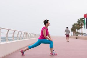 Frau, die sich auf der Promenade ausdehnt und aufwärmt foto