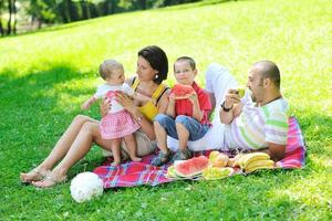 glückliches junges Paar mit ihren Kindern haben Spaß im Park foto