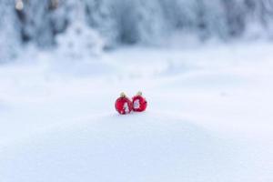 rote weihnachtskugeln im frischen schnee foto