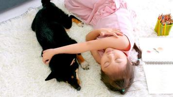 Asiatisches kleines Mädchen, das zu Hause mit ihrem Hund schläft. foto