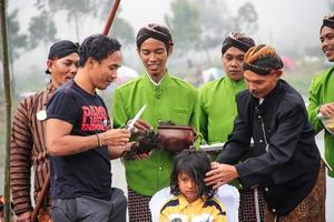 dieng, indonesien - 1. august 2015. dieng-kulturfestival, touristen folgen der dreadlocks-prozession während der dieng-kulturfestivalveranstaltung in dieng, banjarnegara-bezirk, zentrales java foto