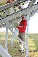 Ingenieur mit Laptop auf dem Feld der Solaranlage foto