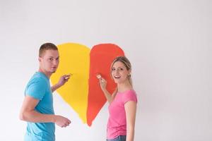 Paar malt ein Herz an die Wand foto