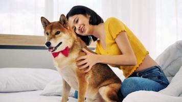 glückliche frau und shiba inu hund liegen zusammen auf einem bett zu hause foto