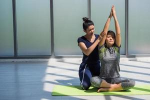 Zwei asiatische Frauen, die gemeinsam Yoga in einem Fitnessstudio machen. foto