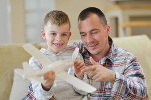 Vater und Sohn bauen Flugzeugspielzeug zusammen foto