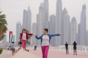 Mutter und süßes kleines Mädchen auf der Promenade foto