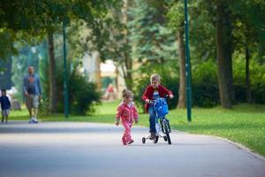 Junge und Mädchen mit Fahrrad foto