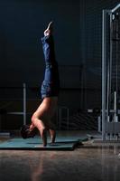 junger mann, der handstand im fitnessstudio durchführt foto