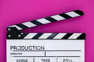Filmklöppel auf rosa lila violettem Hintergrund foto