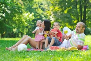 glückliches junges Paar mit ihren Kindern haben Spaß im Park foto