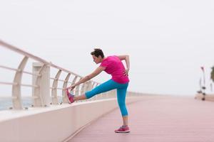 Frau, die sich auf der Promenade ausdehnt und aufwärmt foto