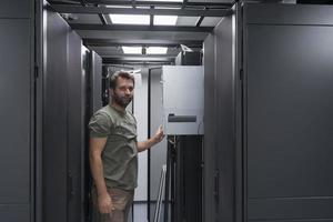 it-ingenieur, der im serverraum oder rechenzentrum arbeitet, stellt der techniker einen neuen server eines großrechner-supercomputers oder einer kryptowährungs-mining-farm in ein rack. foto