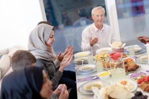 Moderne multiethnische muslimische Familie betet vor dem Iftar-Abendessen foto