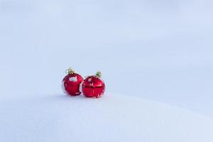 rote weihnachtskugeln im frischen schnee foto