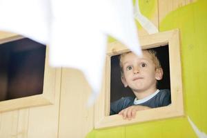 glückliches Kind in einem Fenster foto