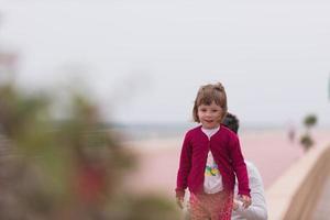 Mutter und süßes kleines Mädchen auf der Promenade am Meer foto