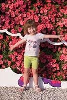 kleines süßes Mädchen in einem Blumengarten foto