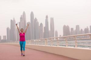 junge Frau, die einen erfolgreichen Trainingslauf feiert foto