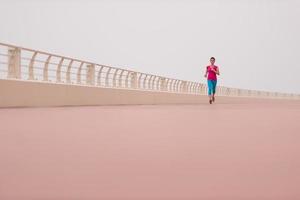 Frau, die damit beschäftigt ist, auf der Promenade zu laufen foto