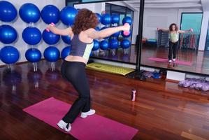 junge hübsche Frau, die in einem Fitnesscenter trainiert foto