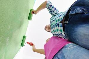 Glückliches Paar malt Wand im neuen Zuhause foto