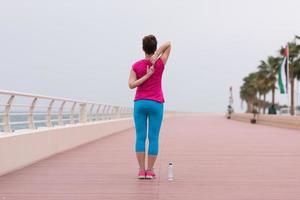 Frau, die sich auf der Promenade ausdehnt und aufwärmt foto