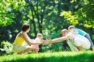 glückliches junges Paar mit ihren Kindern haben Spaß im Park foto