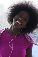 Porträt einer jungen afroamerikanischen Frau im Fitnessstudio, während sie Musik hört foto