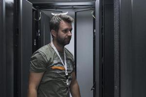 it-ingenieur, der im serverraum oder rechenzentrum arbeitet, stellt der techniker einen neuen server eines großrechner-supercomputers oder einer kryptowährungs-mining-farm in ein rack. foto