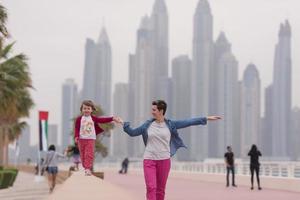 Mutter und süßes kleines Mädchen auf der Promenade foto