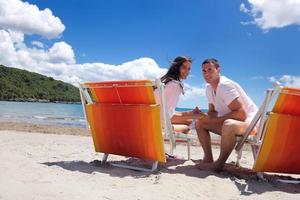 Glückliches Paar hat Spaß am Strand foto