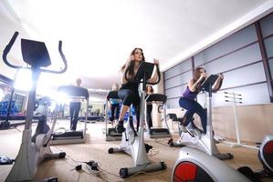Frau, die im Fitnessstudio auf Spinning-Bike trainiert foto