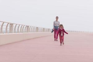 Mutter und süßes kleines Mädchen auf der Promenade am Meer foto