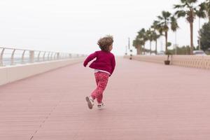 süßes kleines Mädchen auf der Promenade am Meer foto