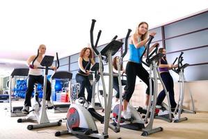 Frauen, die im Fitnessstudio auf Spinning-Rädern trainieren foto