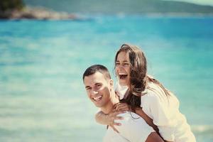 Glückliches Paar hat Spaß am Strand foto