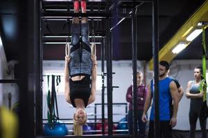 frau, die mit persönlichem trainer an gymnastikringen trainiert foto