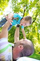 glücklicher vater und sohn haben spaß im park foto