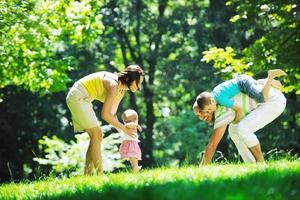 glückliches junges Paar mit ihren Kindern haben Spaß im Park foto