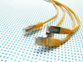 Gelbes Ethernet-Kabel auf gepunktetem Hintergrund foto