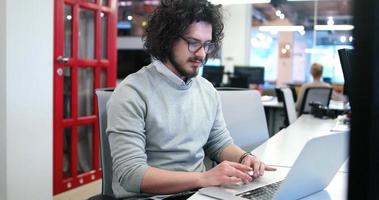 Geschäftsmann, der mit einem Laptop im Startup-Büro arbeitet foto