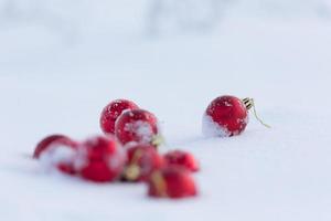 rote weihnachtskugeln im frischen schnee foto