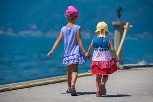kleine Schwestern, die an der Strandküste spazieren gehen foto