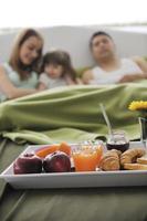 Glückliche junge Familie frühstückt im Bett foto