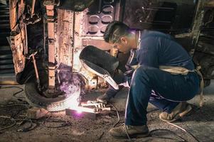 junger Mann Mechaniker Arbeiter reparieren alte Oldtimer Karosserie