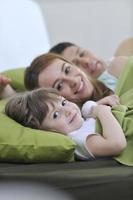 glückliche familie, die sich im bett entspannt foto