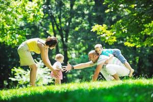 glückliches junges Paar mit ihren Kindern haben Spaß im Park foto