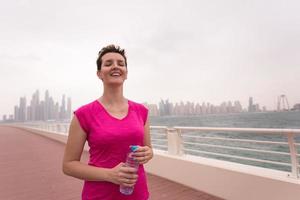 junge Frau, die einen erfolgreichen Trainingslauf feiert foto